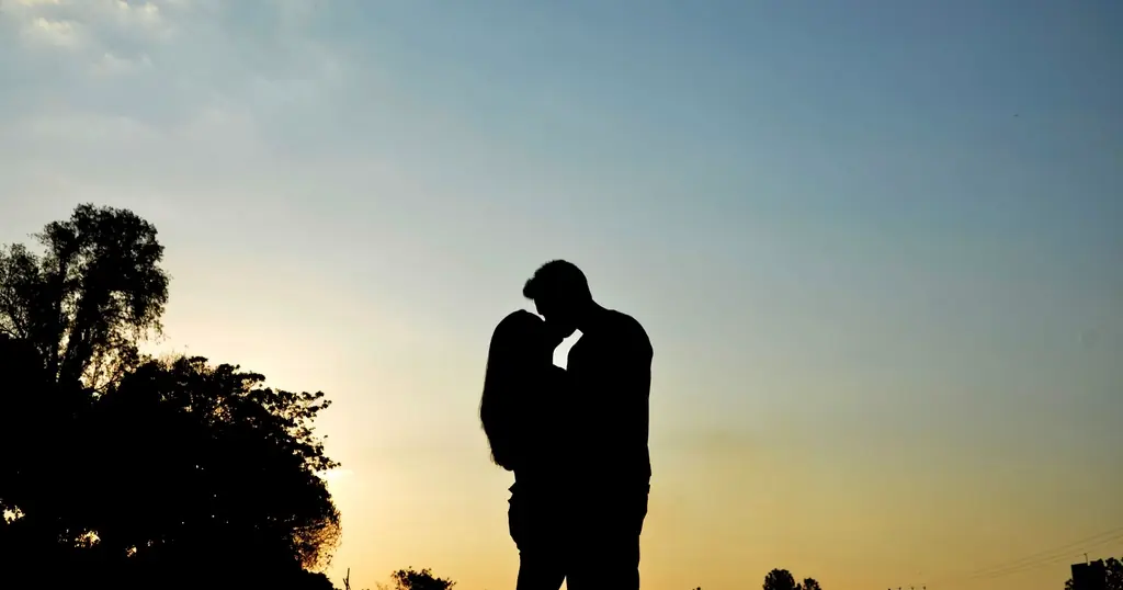 Plan cul en France : un couple s'embrasse en silhouette au coucher du soleil