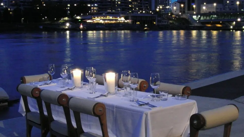 Plan cul Île-de-France : une table dressée aux chandelles au bord de l'eau la nuit