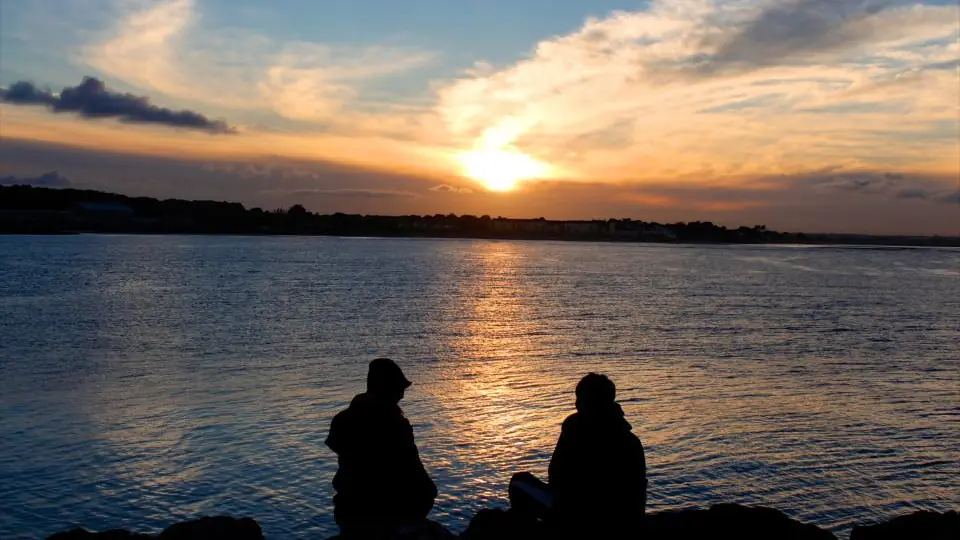 Plan cul Marseille : un couple en silhouette au bord de l'eau au coucher du soleil
